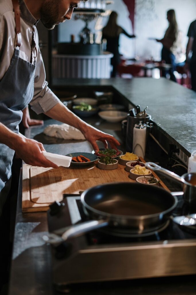 Chef organizing ingredients at a restaurant kitchen counter, ready for cooking.